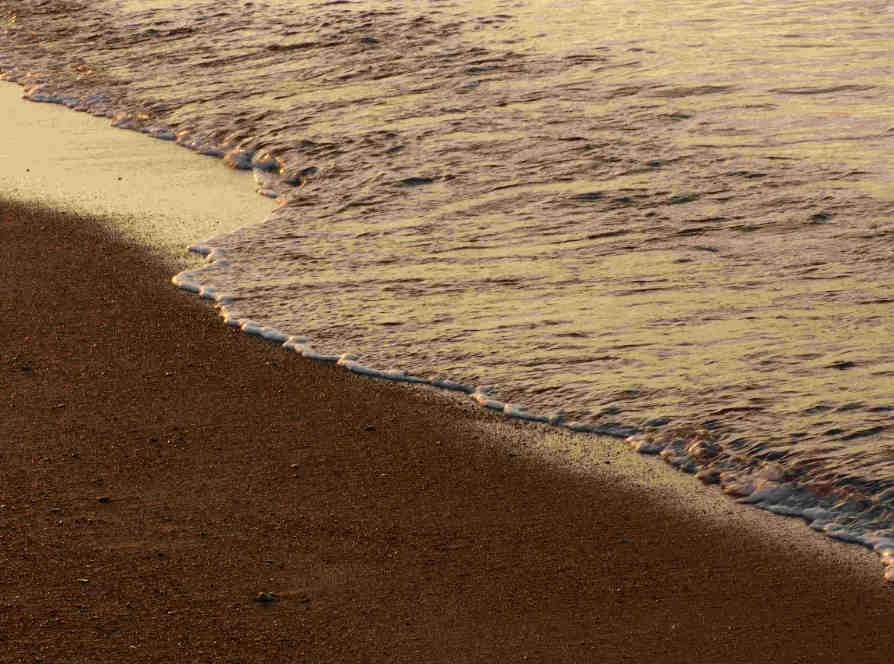 Close-up of a wave rolling onto the beach.